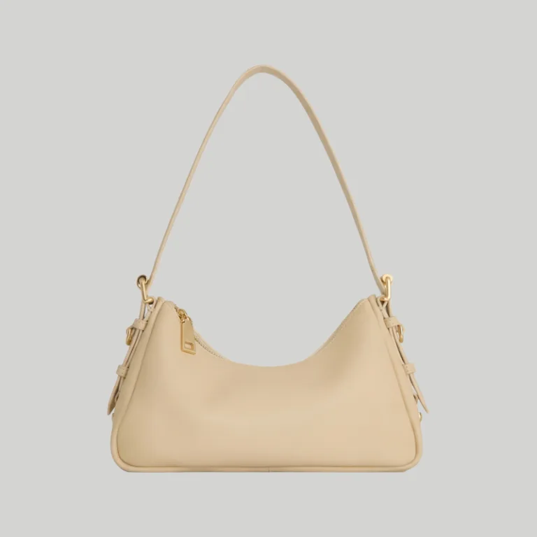 Front view of minimalist beige leather shoulder bag with adjustable strap and gold hardware