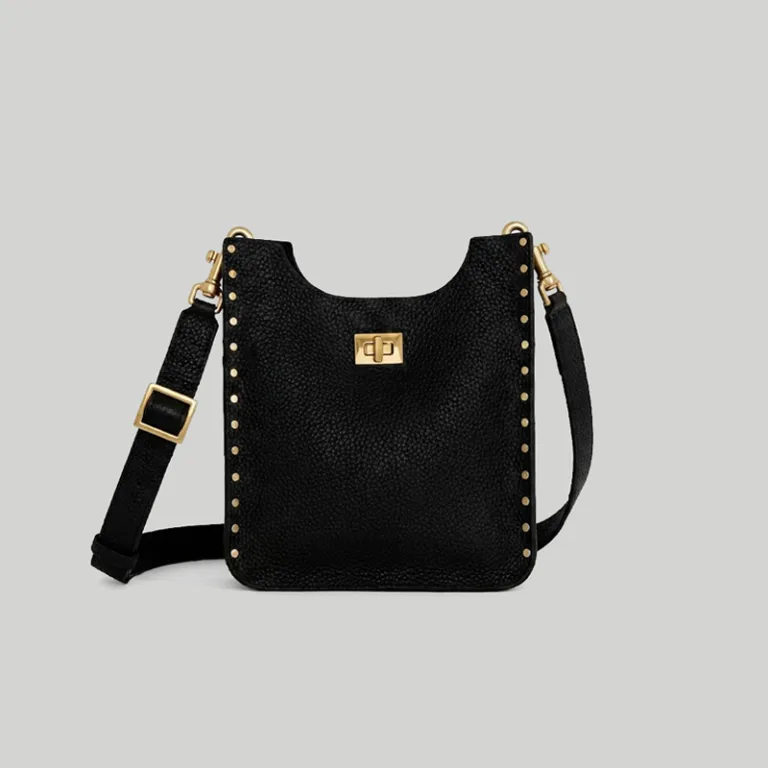 Close-up macro view of the rectangular gold turn-lock closure on the minimalist black studded shoulder bag