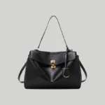 Front view of elegant black slouchy satchel featuring a top handle and crossbody strap.