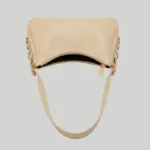 Angled view highlighting the top zipper and gold-tone clasp details on a beige leather shoulder bag