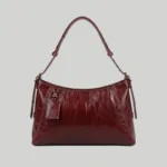 Front view of slouchy red plant-based leather tote showing artisan white contrast stitching.