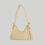 Side profile of structured beige shoulder bag showing the 9cm gusset depth and strap attachments