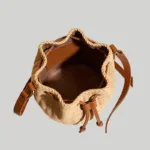 Inside view of bucket bag showing textile lining, faux-leather base, and interior slip pocket