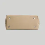 Flat rectangular bottom base of structured handbag featuring protective silver-tone metal feet
