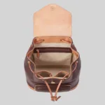 Interior view of wholesale leather backpack showing fabric lining, internal zipper pocket, and dual slip compartments.