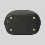 Structured flat base of a quiet luxury top-grain cowhide bucket bag featuring four polished gold-tone metal protective feet.