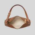 Top view showing open zipper and light fabric lining of quiet luxury leather shoulder bag