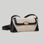 Front view of quiet luxury canvas commuter bag with metal lock closure and adjustable strap