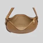 Top-down view of the crescent bag interior showing a soft suede-like lining, spacious main compartment, and zipper closure.