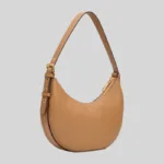 Angled view of a tan structured full-grain cow leather crescent shoulder bag for B2B wholesale and private label.