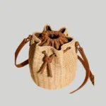 Top view showing cinched faux-leather drawstring closure on a woven summer bucket bag