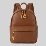 Front view of structured brown top-grain cowhide commuter backpack featuring distinct yellow cord zipper pulls and side pockets for wholesale.