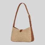 Angle view of women's straw baguette bag highlighting side panels and adjustable shoulder strap