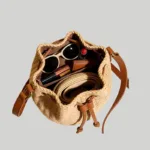 Interior capacity of woven straw bucket bag holding sunglasses, cosmetics, and wallet