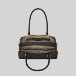 Top open view of the black shoulder bag showing dual compartments, interior lining, and zip pockets