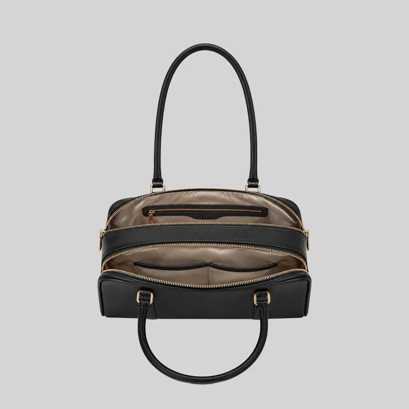 Top open view of the black shoulder bag showing dual compartments, interior lining, and zip pockets