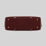 Top open view of the shoulder bag showing dual compartments, interior lining, and zip pockets, burgundy