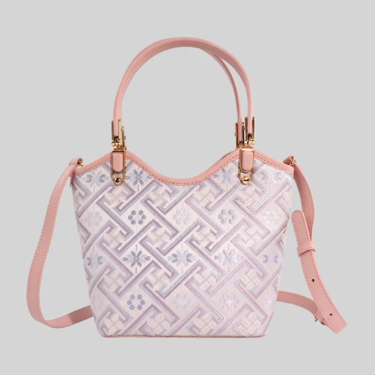Front angled view of a pink jacquard mini tote bag featuring a scalloped top and geometric pattern.