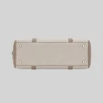 Top open view of the shoulder bag showing dual compartments, interior lining, and zip pockets, beige