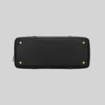 Top open view of the shoulder bag showing dual compartments, interior lining, and zip pockets, black