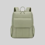 Front view of the sage green pebbled vegan leather laptop backpack featuring a structured silhouette