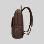 Side profile of the structured dark brown PU laptop daypack showing the elasticized side pocket.